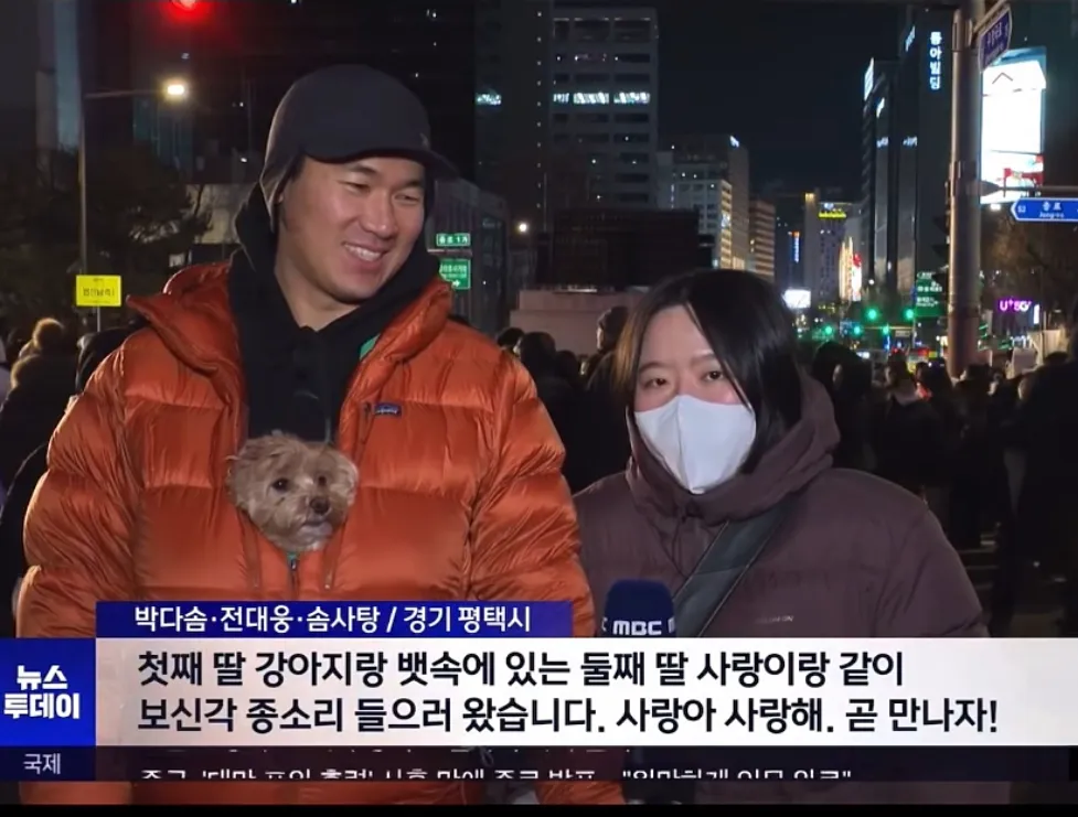 새해맞이 보신각 종각 앞에서 강아지와 함께 한 임신부 가족