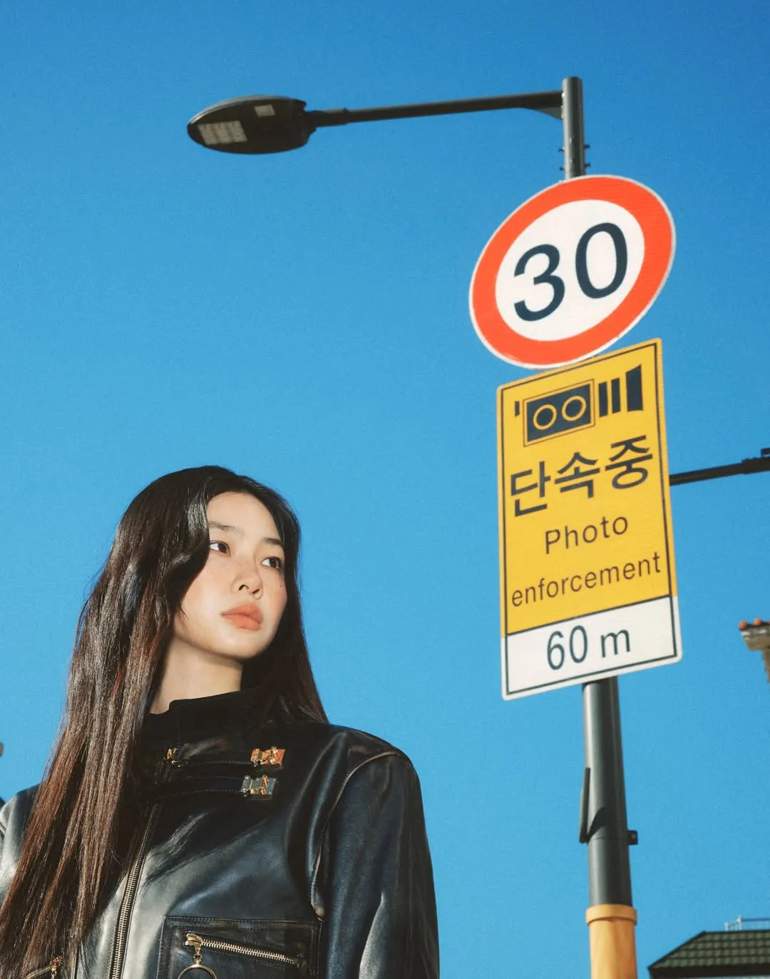 과속단속 표지판 앞에서 포즈를 취한 정호연의 한국풍 화보 사진