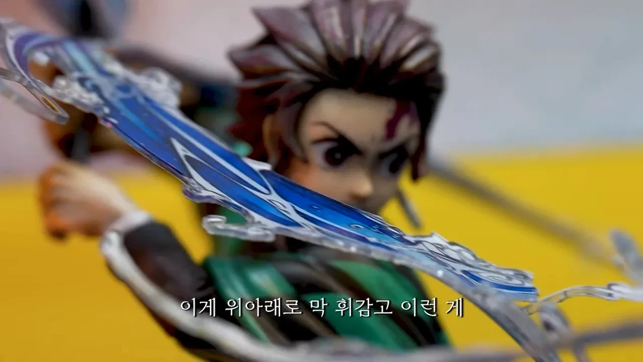 귀멸의 칼날 캐릭터 피규어가 검을 휘두르며 역동적인 포즈를 취한 모습