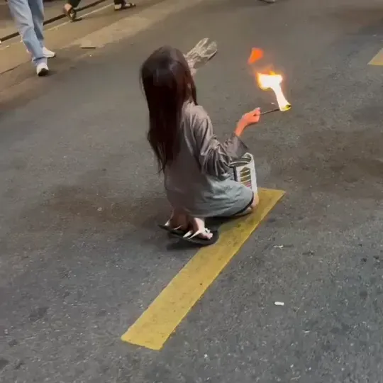 불쇼를 공연하는 베트남 소녀가 입으로 불을 뿜고 있다