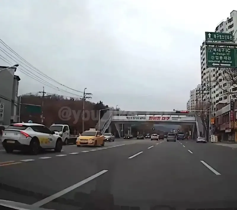 북구청소년회관과 북대구IC 표지판이 보이는 도로, "제16회 칠곡사 넘나드는 파워풀 대구" 현수막