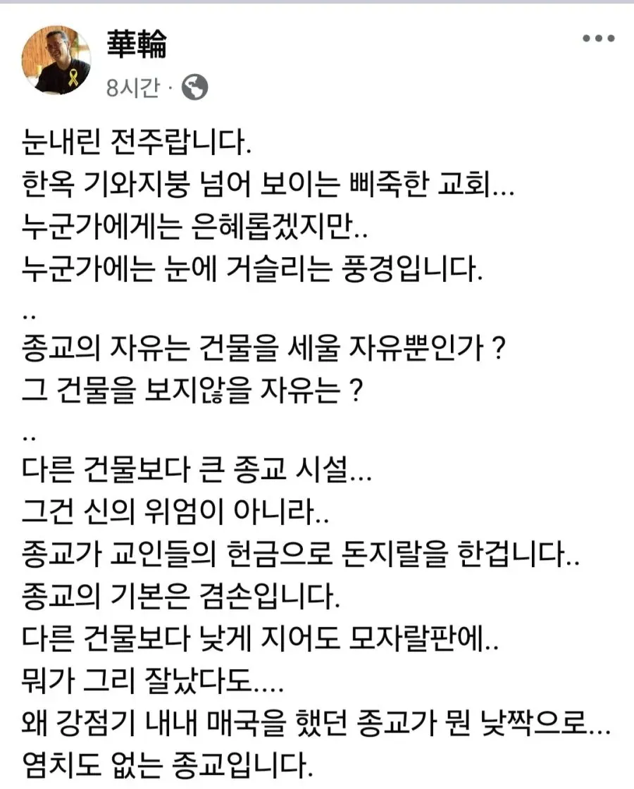 눈 덮인 전주 한옥마을 기와지붕 너머로 보이는 높은 교회 첨탑