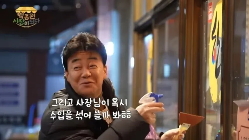 백종원이 예산시장 정육점에 한돈인증 스티커를 붙이고 있는 모습