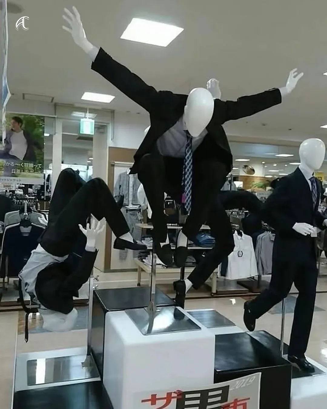 정장의 신축성을 과장되게 보여주는 일본 의류 매장 직원의 유머러스한 포즈