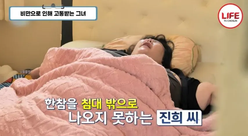 지팡이에 의지한 초고도비만 여성이 반려견과 함께 서 있다