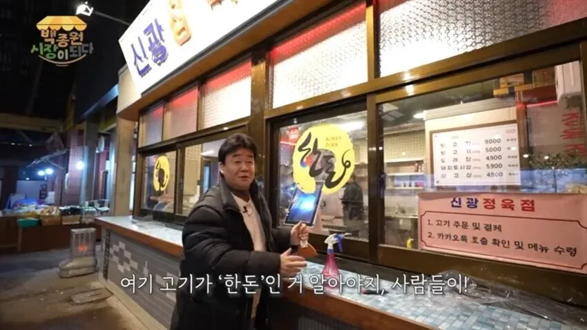 백종원이 예산시장 정육점에 한돈 인증 스티커를 붙이는 모습