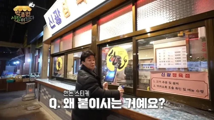 백종원이 예산시장 신광정육점에서 한돈 인증 스티커를 붙이는 모습