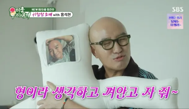 홍석천이 침대에서 "형이라 생각하고 껴안고 자 줘~"라고 말하는 밈 이미지