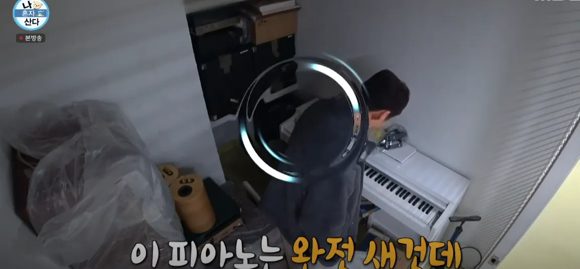 전현무가 새 피아노 앞에서 "이 피아노는 완전 새건데"라고 말하는 장면