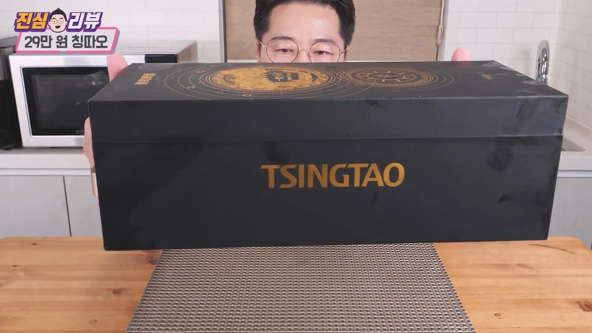 TSINGTAO 로고가 적힌 고급 맥주병을 들고 있는 유튜버