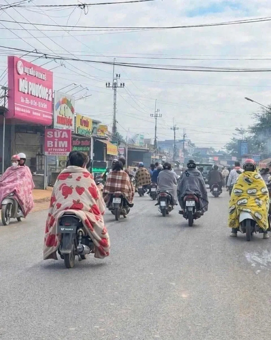 추운 날씨에 담요를 두른 베트남 거리의 분유·기저귀 가게 간판