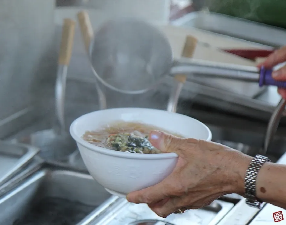 기차역 플랫폼에서 우동을 먹는 승객들의 모습