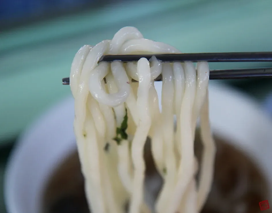 기차역 플랫폼에서 우동을 먹는 승객들의 모습