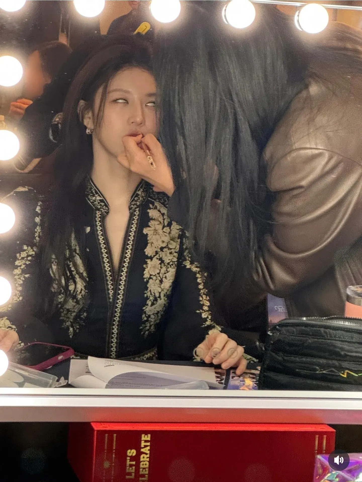 축하 문구가 적힌 배경 앞에서 장난스러운 표정을 짓는 여배우