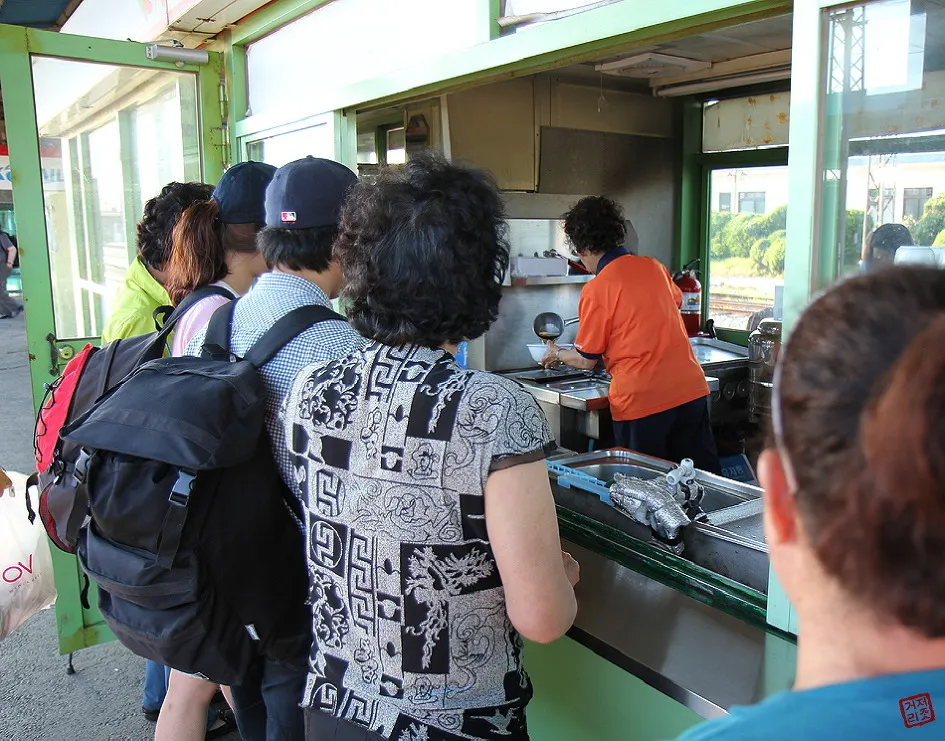 1971년 일본 기차역 플랫폼에서 승객들이 우동을 먹는 흑백 사진