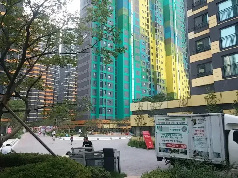 연락처가 적힌 미세방충망 광고가 외벽에 페인트칠된 특이한 도색의 아파트 건물