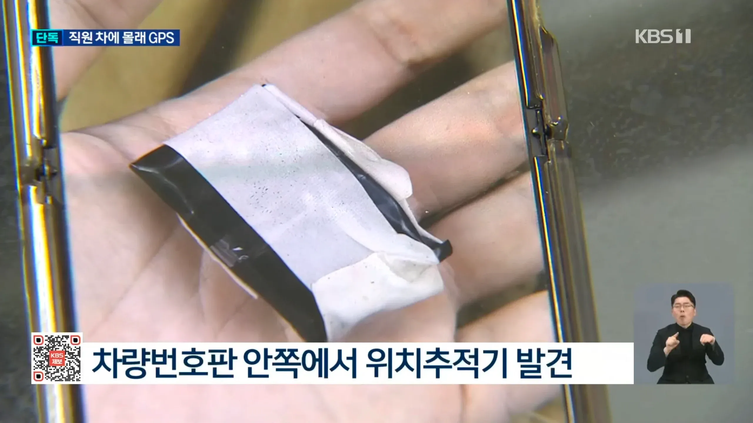 차량 번호판 안쪽에 부착된 GPS 위치추적기가 발견된 모습을 보도하는 KBS 뉴스 화면