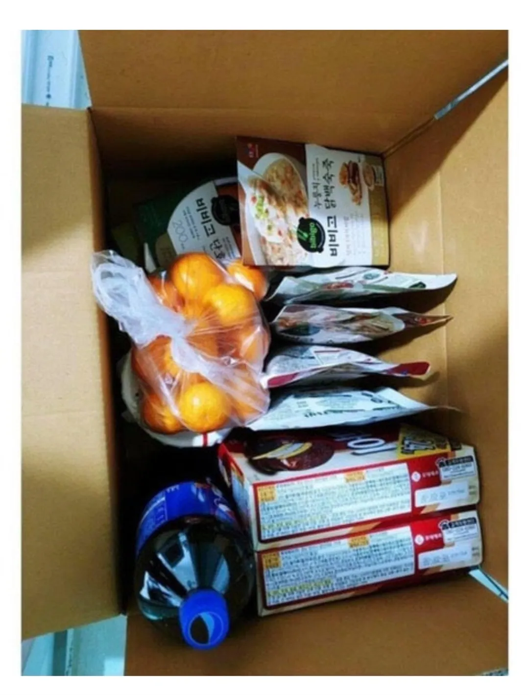 책상 위에 놓인 비비고 디미방, 잡채볶음밥, 볶음너구리, 우유, 육개장 사발면