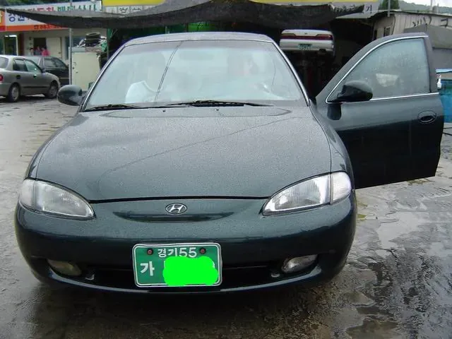 `90년대 감성의 경기55 번호판이 부착된 연두색 자동차`