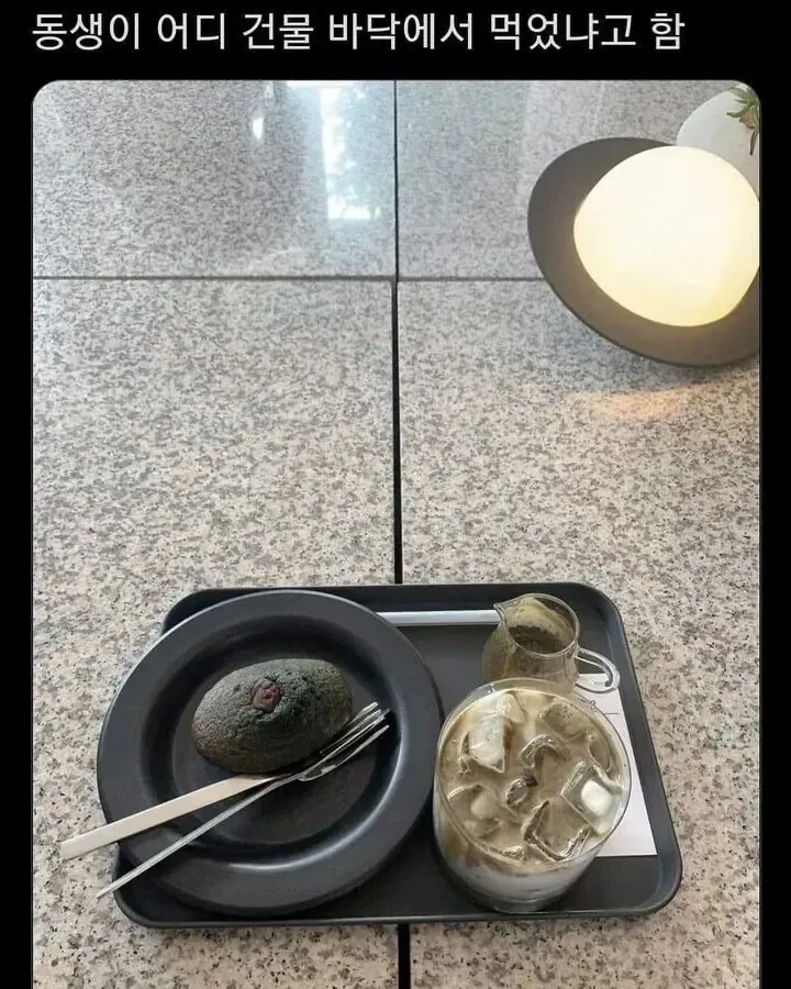 건물 바닥에 앉아 커피를 마시는 여성