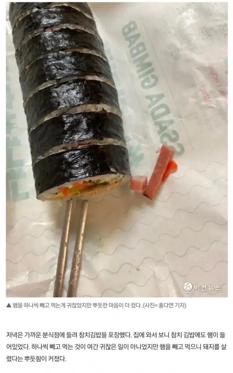 참치김밥에서 햄을 하나씩 빼고 먹는 비건 기자의 모습