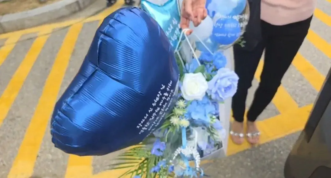 배우 김수현이 여성팬으로부터 꽃과 파란 하트 풍선을 받은 모습