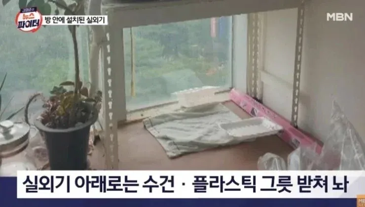 에어컨 실외기 아래 수건과 플라스틱 그릇이 방치된 상태