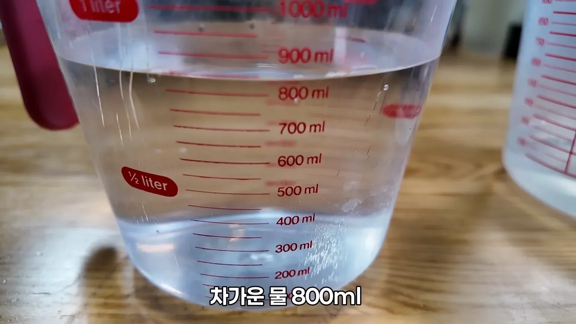 계량컵에 표시된 눈금 중 800ml 지점까지 찬 물을 담는 모습