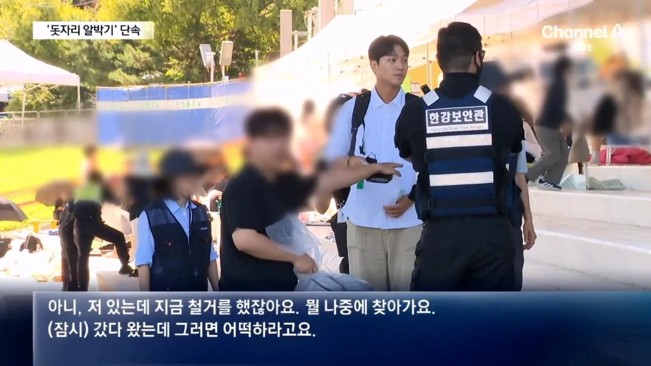 불꽃축제 자리 선점을 위해 깔아둔 돗자리가 철거되자 50대 남성이 항의하고 있다.