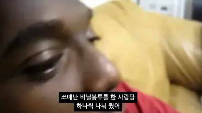 흑인 아이들에게 작은 비닐봉투를 한 사람당 하나씩 나눠 줌