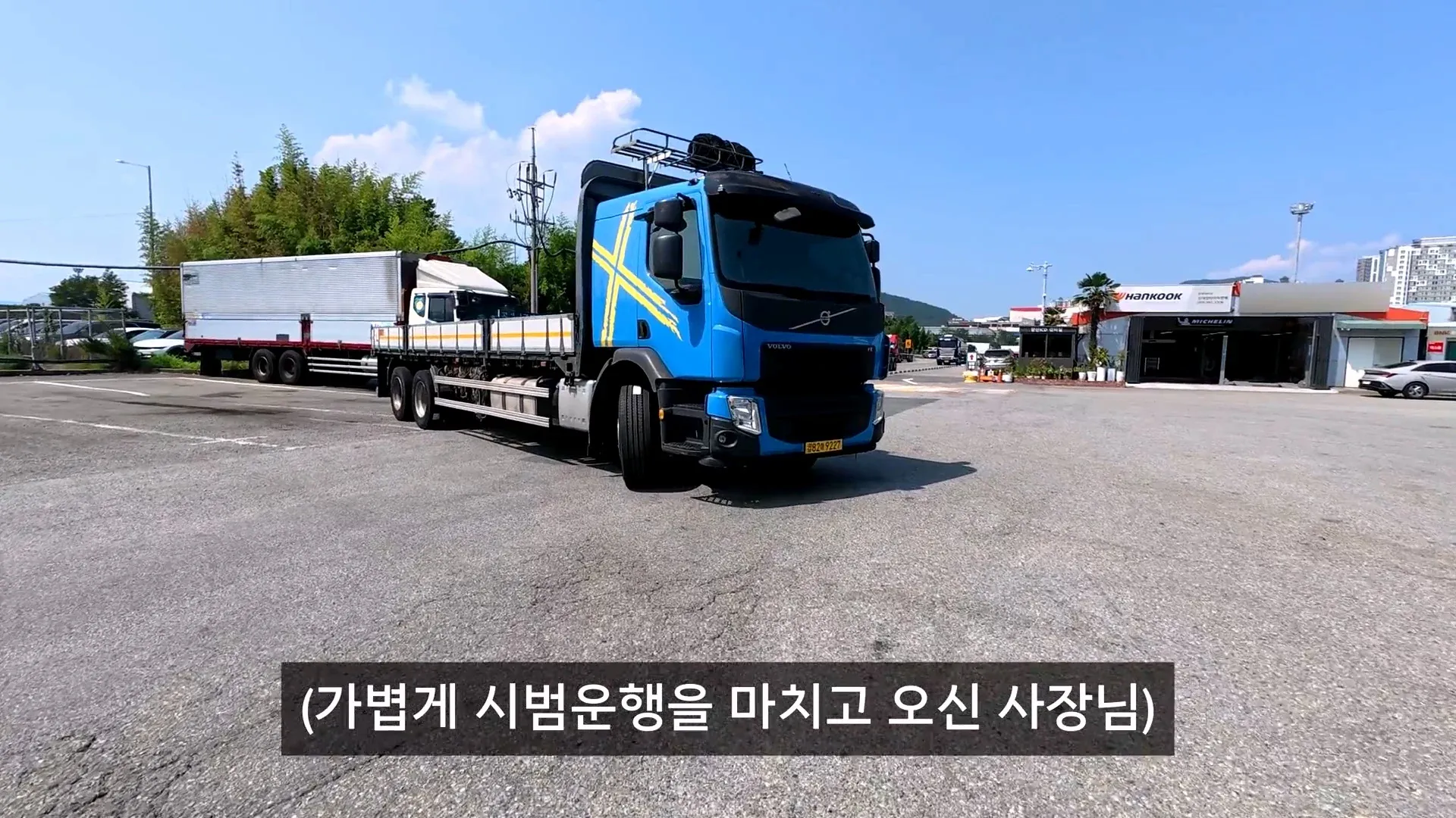 덤프트럭 유튜버가 심하게 마모된 타이어를 살펴보고 있다