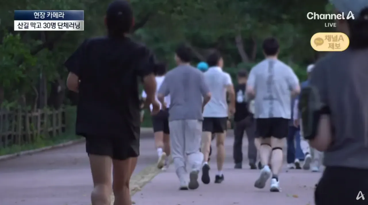 산길을 막고 단체로 달리는 약 30명의 러너들
