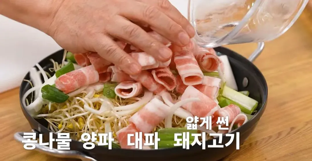 얇게 썬 콩나물, 양파, 대파, 돼지고기가 놓여 있다