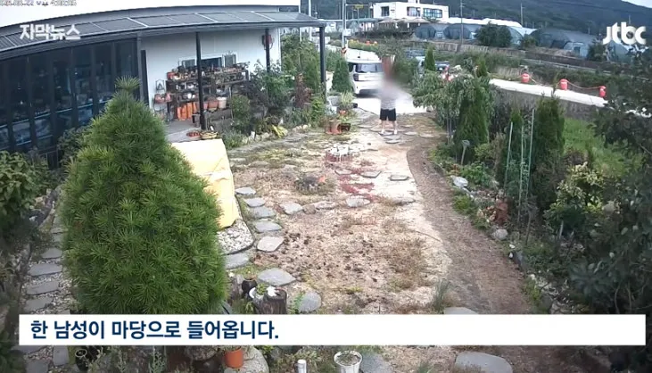 한 남성이 마당으로 들어오는 모습.