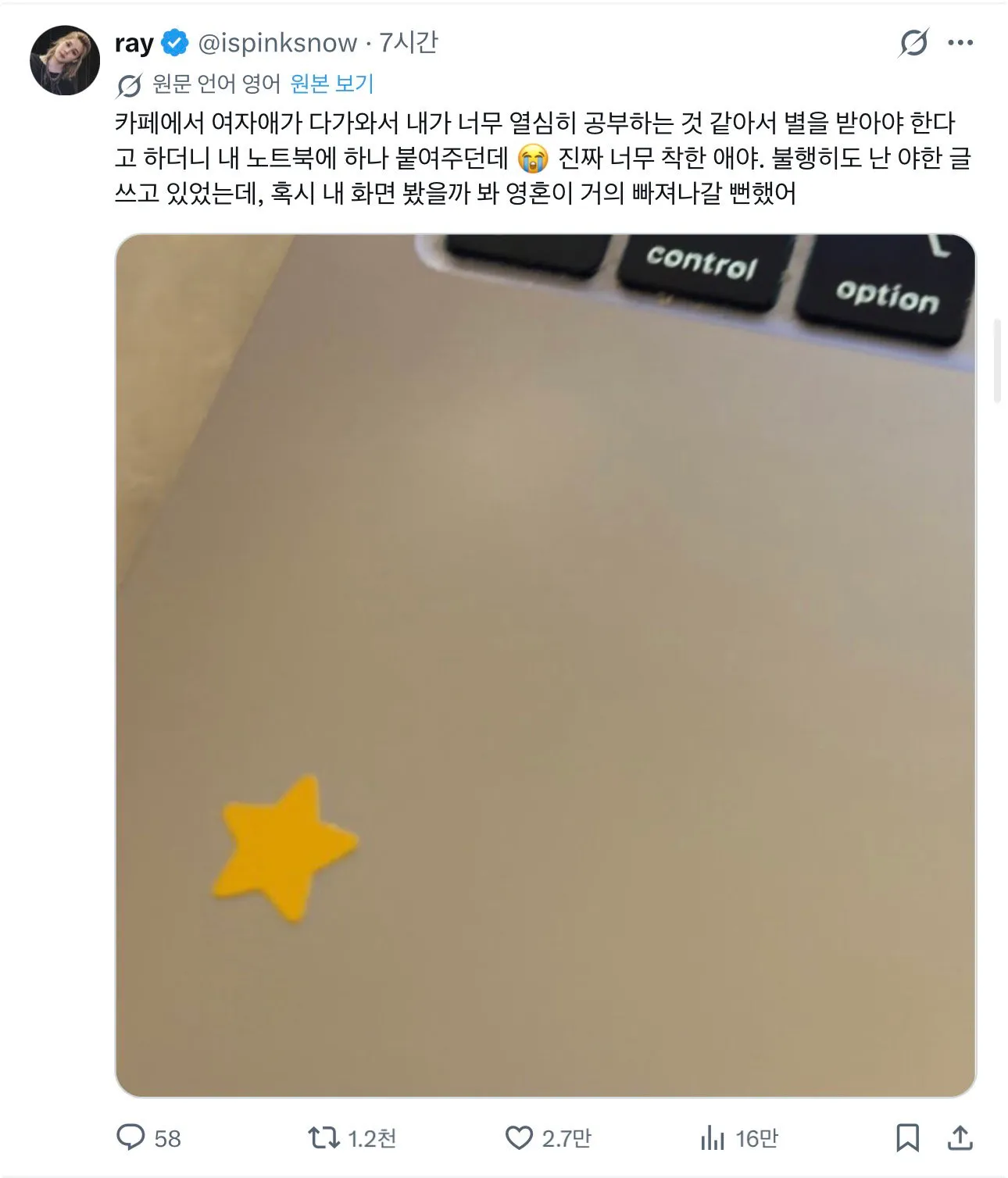 카페에서 여성이 공부 중인 사람의 노트북에 별 스티커를 붙이고 있다